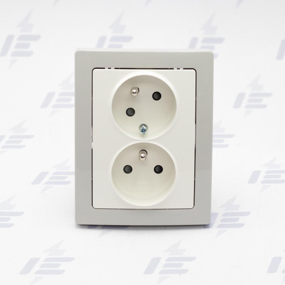 5513J-C02357 B1S1 Zásuvka dvojnásobná ABB Swing s kolíkem a clonkami, natočená dutina, jasně bílá / světle šedá